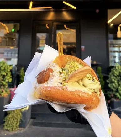 Un panino con crema di pistacchio davanti all'ingresso di Dolce&Salato a Mascalucia